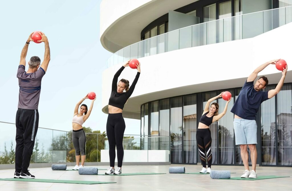 Outdoor yoga session with group stretching at Wellness Privé.