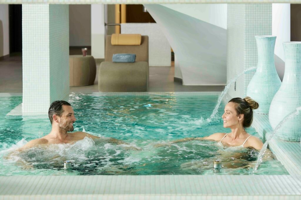 Couples enjoying hydrotherapy pool at longevity hotel Algarve
