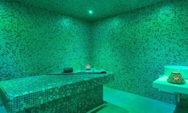 Green tiled steam and sauna wellness room.