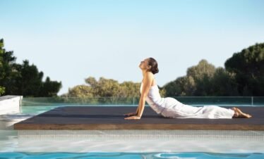 Woman practicing fitness by the pool at Wellness Privé Portugal.