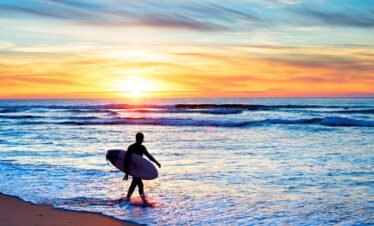 Surfer catching a wave at sunset in Portugal