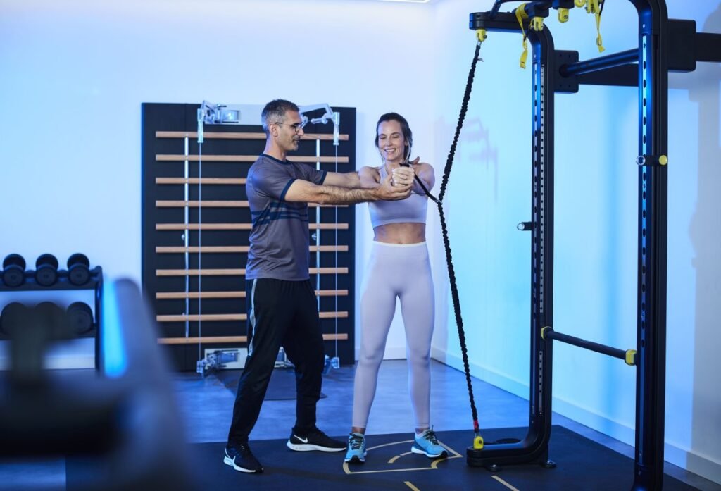 Personal trainer guiding client in fitness studio at wellness retreats Portugal