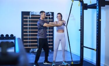 Personal trainer guiding client in fitness studio at wellness retreats Portugal