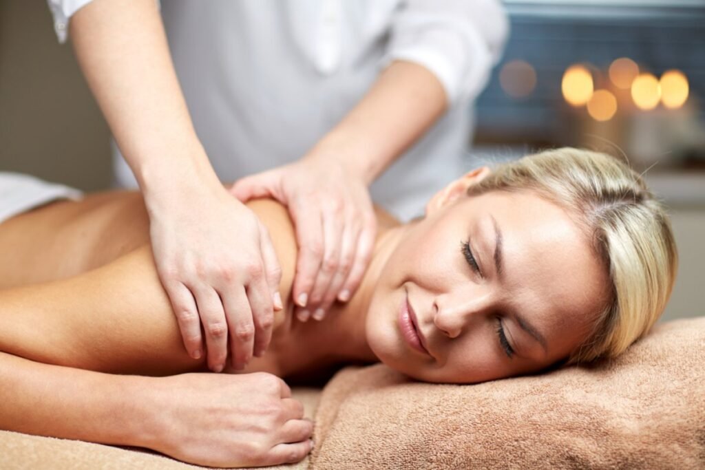 Professional spa therapist giving shoulder massage.