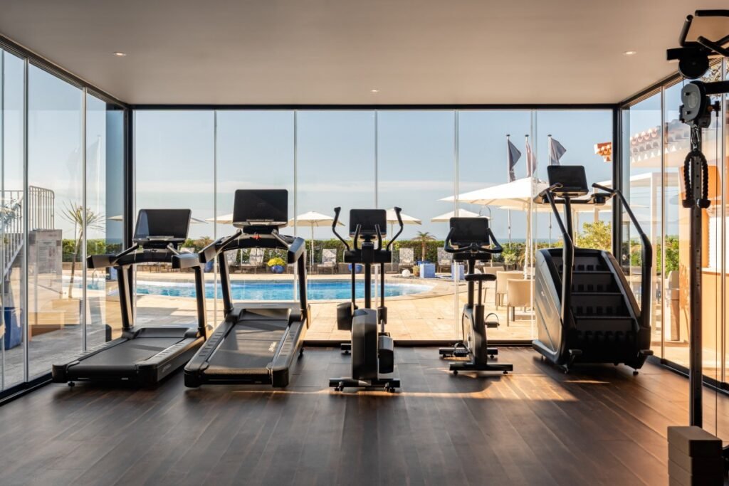 Modern fitness gym with ocean view at Portugal retreat.