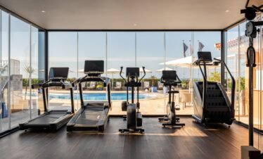 Modern fitness gym with ocean view at Portugal retreat.