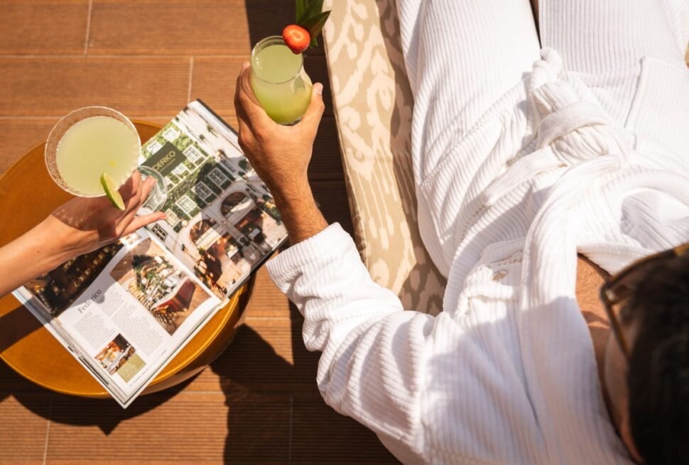 Guest relaxing with fresh juice and magazine at the sea-view balcony for stress-relief