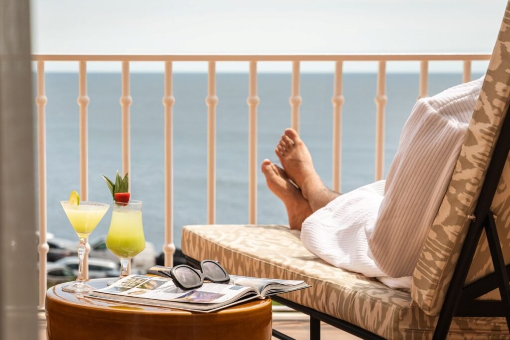 Ocean balcony relaxation with cocktail at Portugal wellness resort.