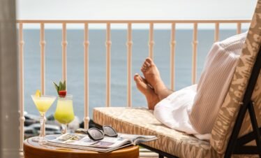 Ocean balcony relaxation with cocktail at Portugal wellness resort.