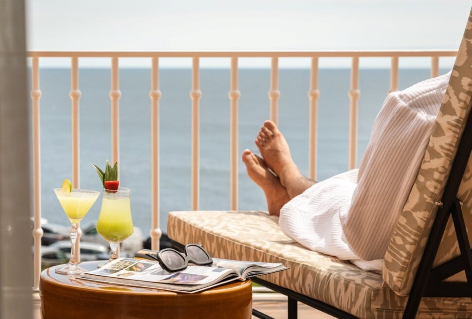 Ocean balcony relaxation with cocktail at Portugal wellness resort.