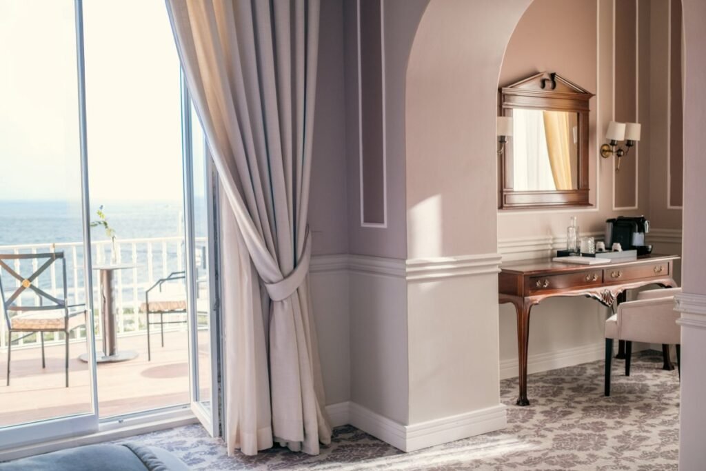 Elegant wellness suite with luxury curtains and sea view.