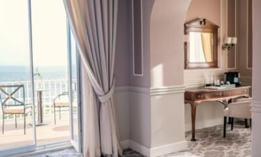 Elegant wellness suite with luxury curtains and sea view.