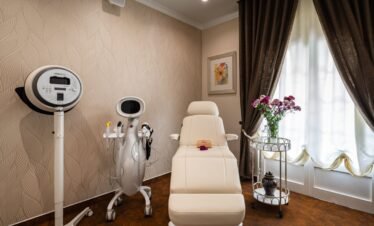 Spa treatment room with massage bed and medical equipment.