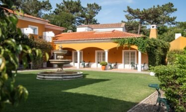 Luxury villa with spacious lawn at Portugal wellness retreat.