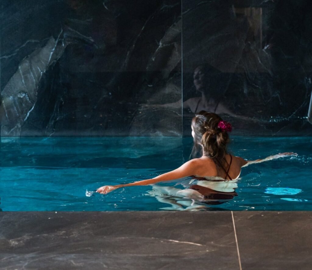 Indoor spa pool with guest relaxing at Wellness Privé.