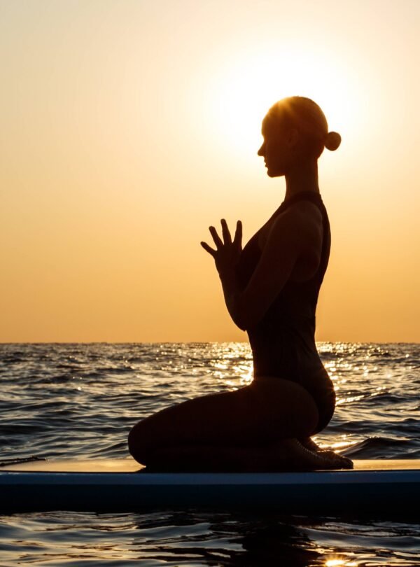 Yoga meditation pose at sunset on the beach.